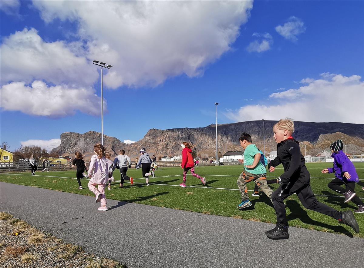 bildet viser barn som løper på skolegården på en finværsdag - Klikk for stort bilde